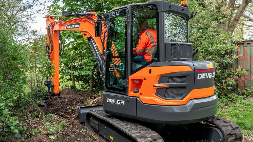 A mini excavator working in a wooded area.
