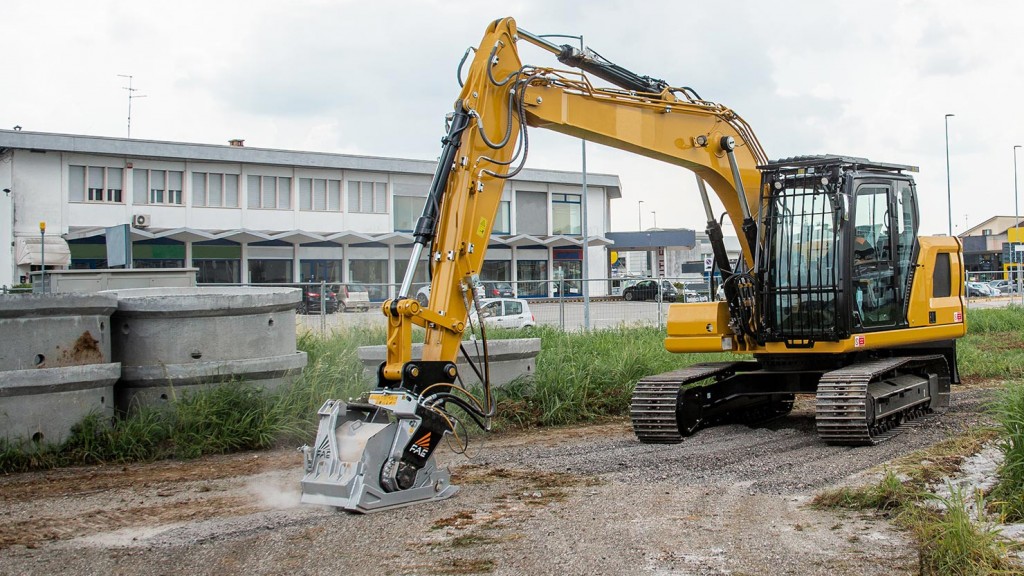 An excavator fitted with a cold planer works on a roadbed.