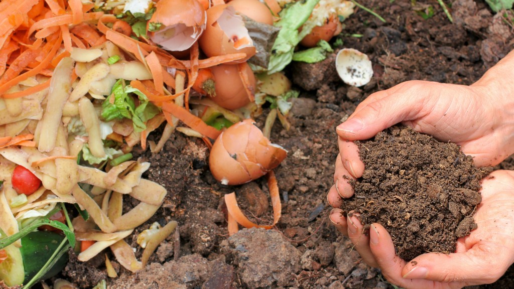 Two hands hold soil near food scraps