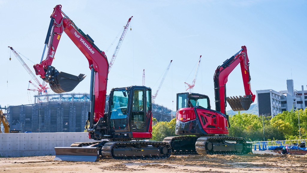 Two mini excavators are parked on a job site