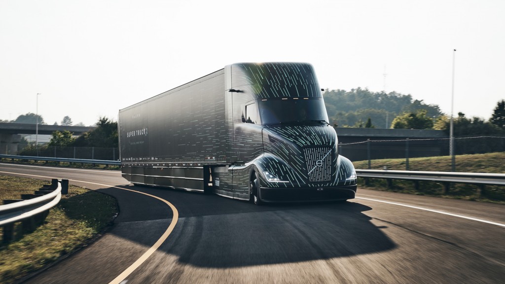 A streamlined, aerodynamic tractor-trailer truck on a curving road.