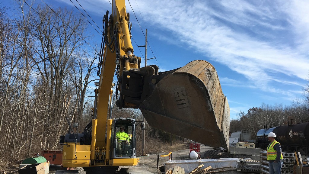 An excavator tilts its bucket with a tilt coupler