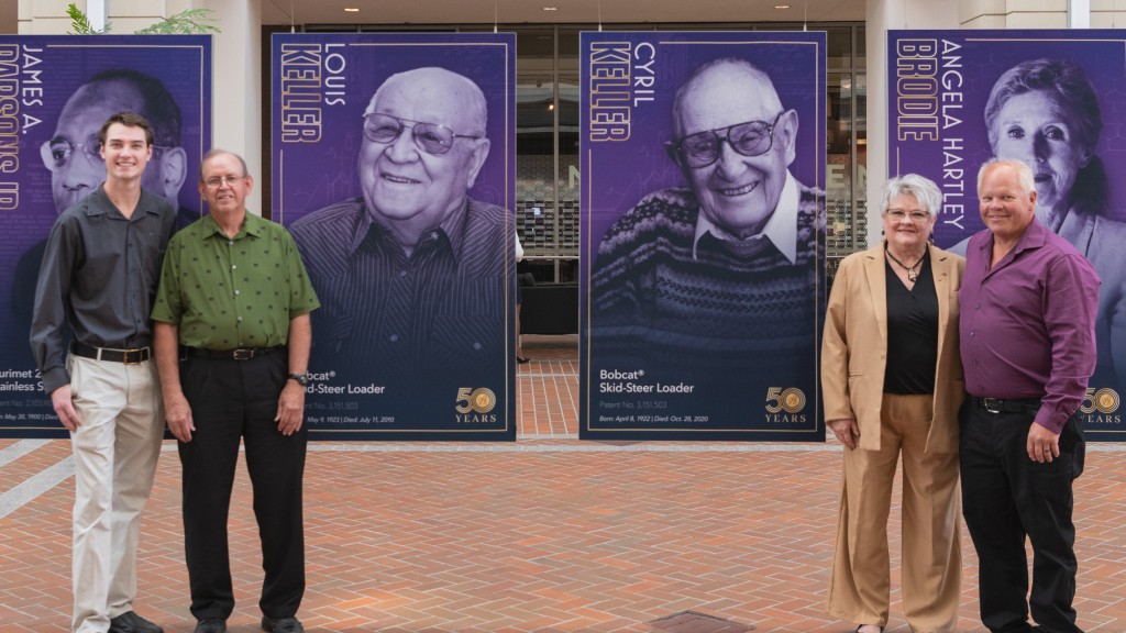 Members of the keller familiy stand near National Inventors Hall of Fame banners