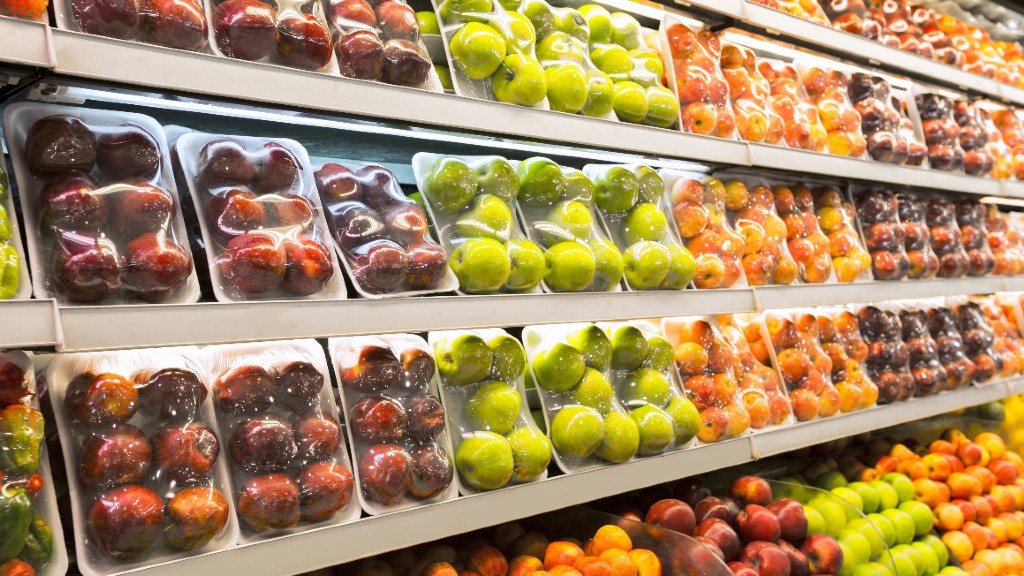 Fresh produce is wrapped in plastic on a store shelf