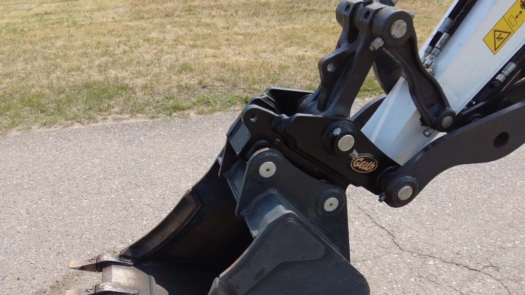 A mechanical quick coupler attached to a bucket on an excavator.