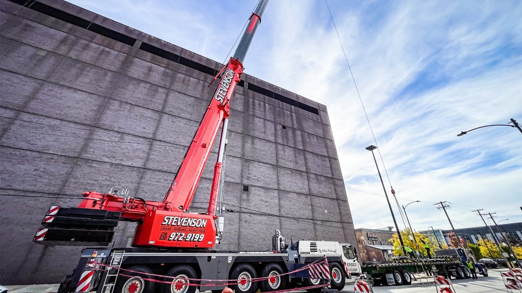 A large mobile crane in front of a building.