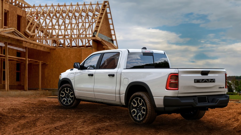 A pickup truck parked in front of a house under construction.