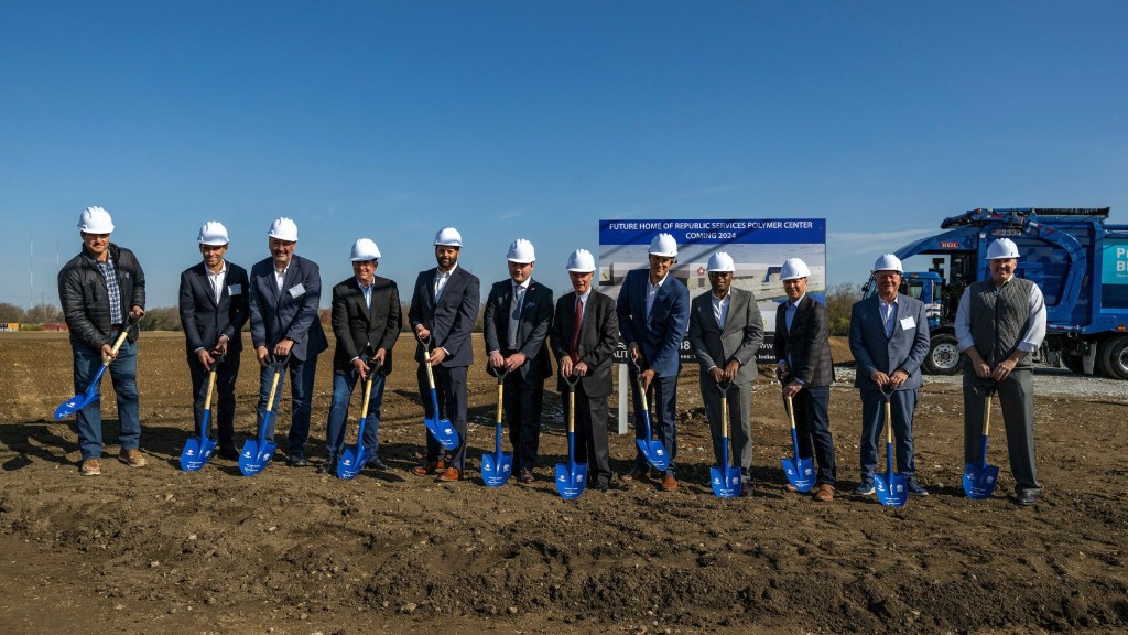 A group of people perform a groundbreaking ceremony in a field