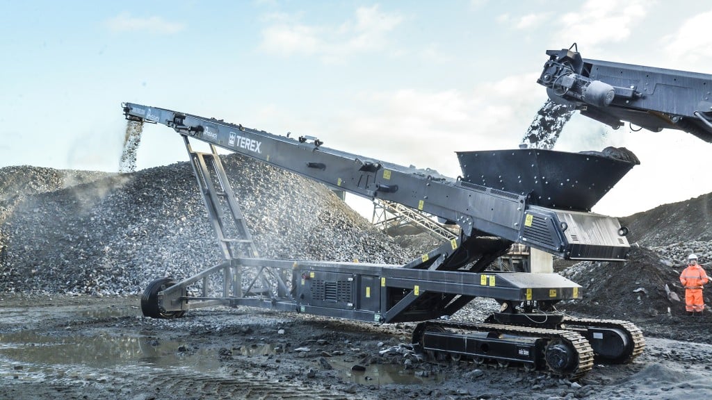 A conveyor takes in crushed rock and places it on a stockpile in a quarry.