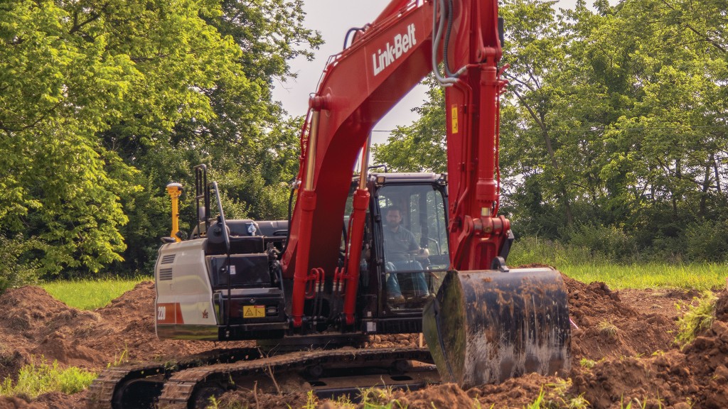 An excavator digs up a portion of a small field