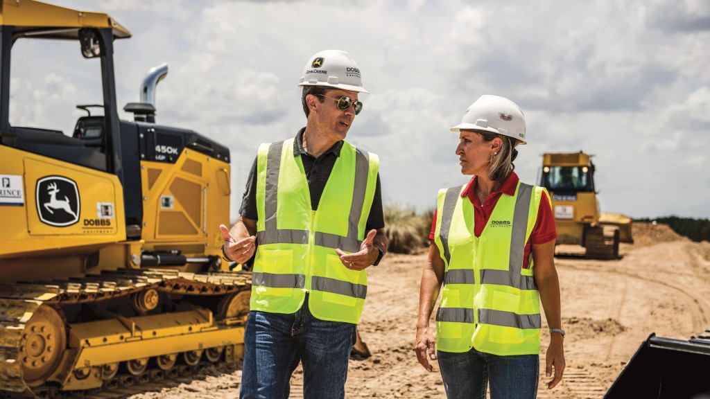 Two workers talk on a job site