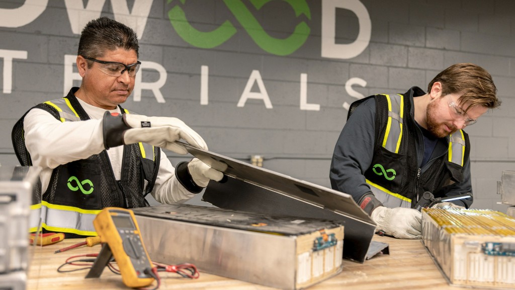 Workers disassemble batteries