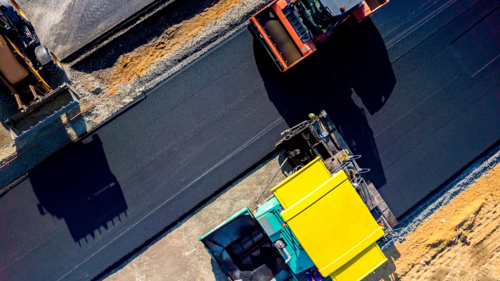 An aerial view of road construction equipment laying asphalt.