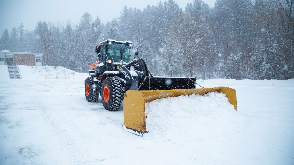A wheel loader plows snow