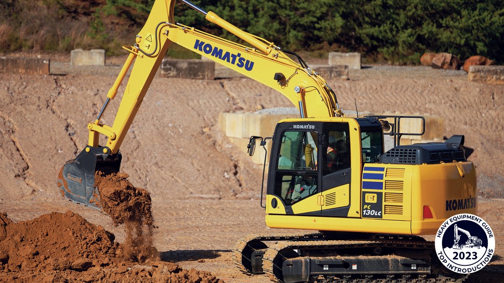 An excavator dumps dirt out of its bucket