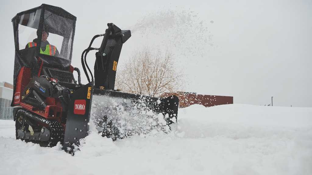 A Toro snow thrower on a TX 1000 compact utility loader