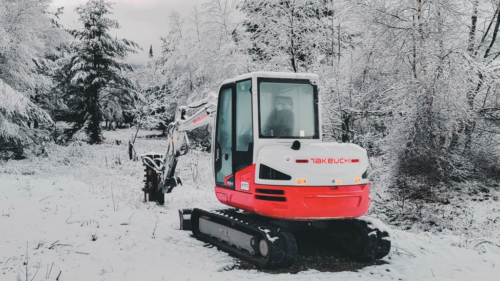 A compact excavator operates in cold weather