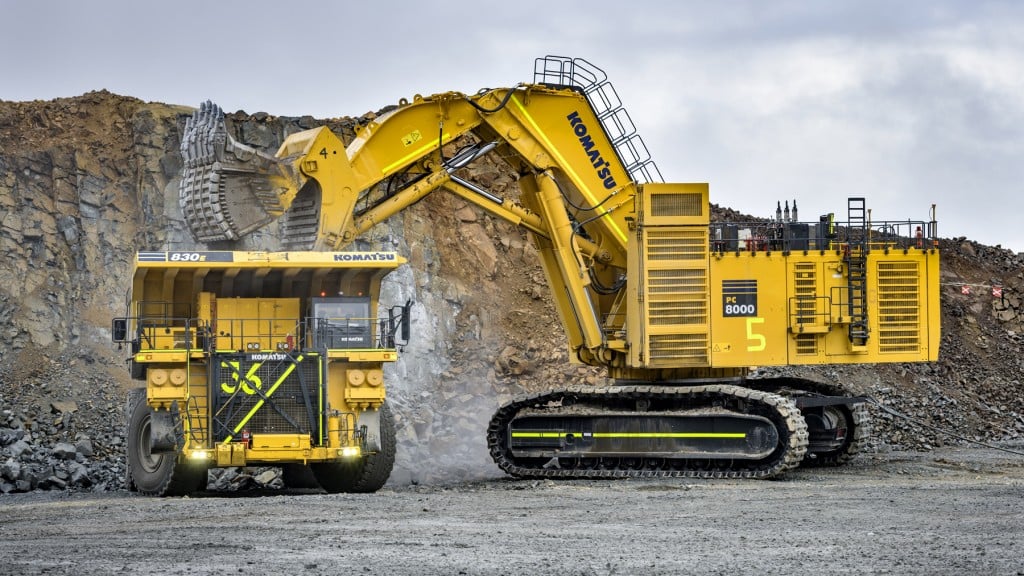 A giant mining excavator loads a mining haul truck.