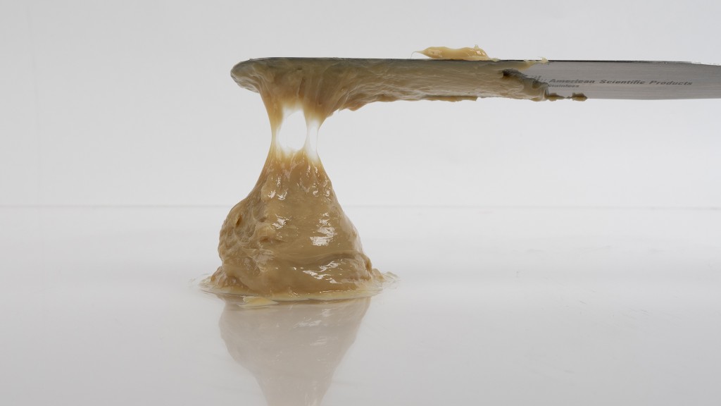 A blob of grease on a white table with a spatula.