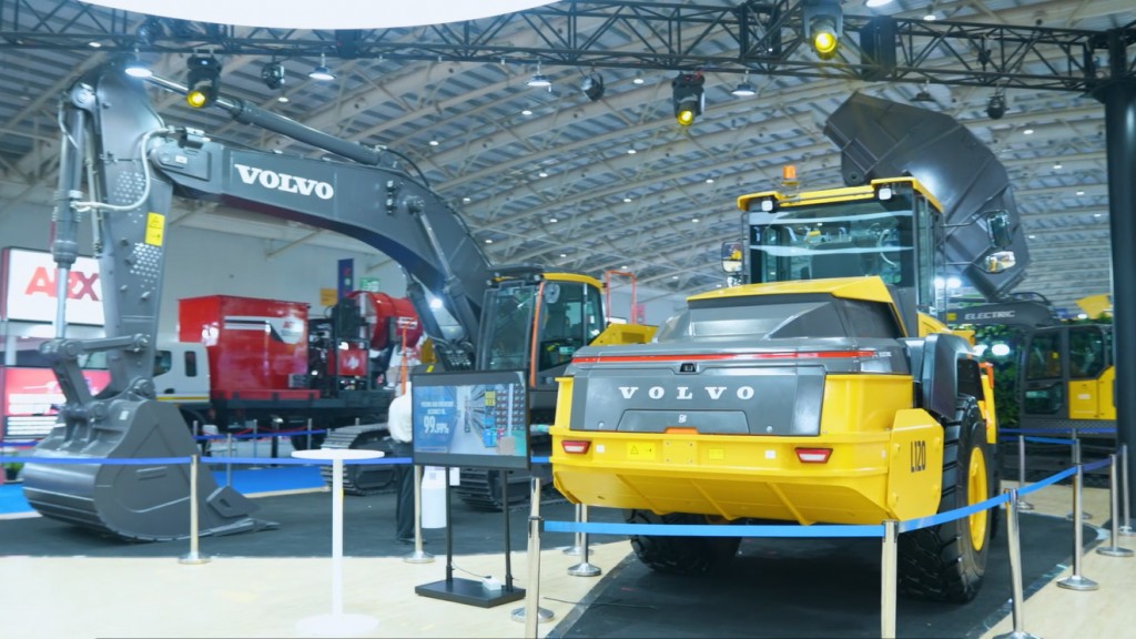 Heavy equipment on display in a trade fair hall.