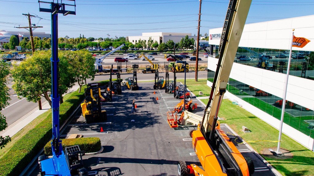 A collection of aerial lifts and other machines in a rental yard.