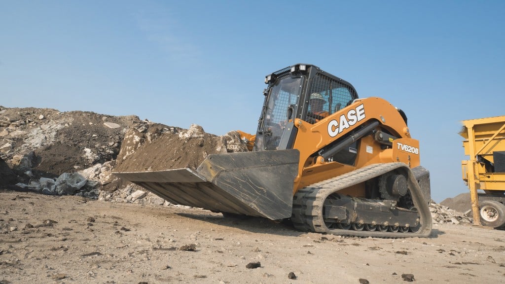 A compact track loader moves a load of dirt with its bucket