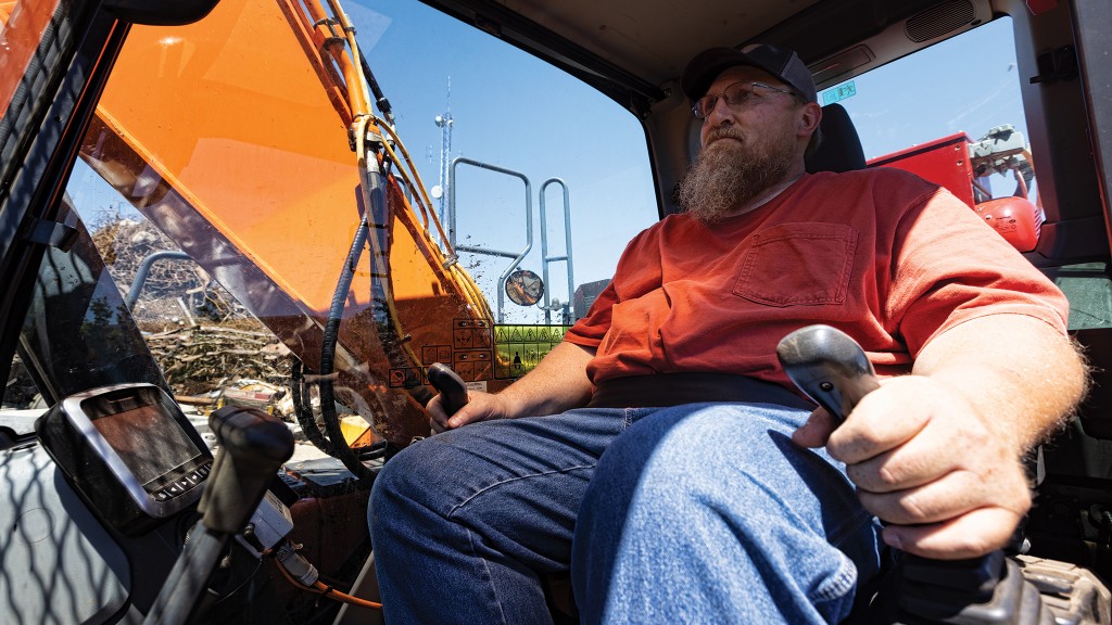 An operator sits in the cab of a material handler