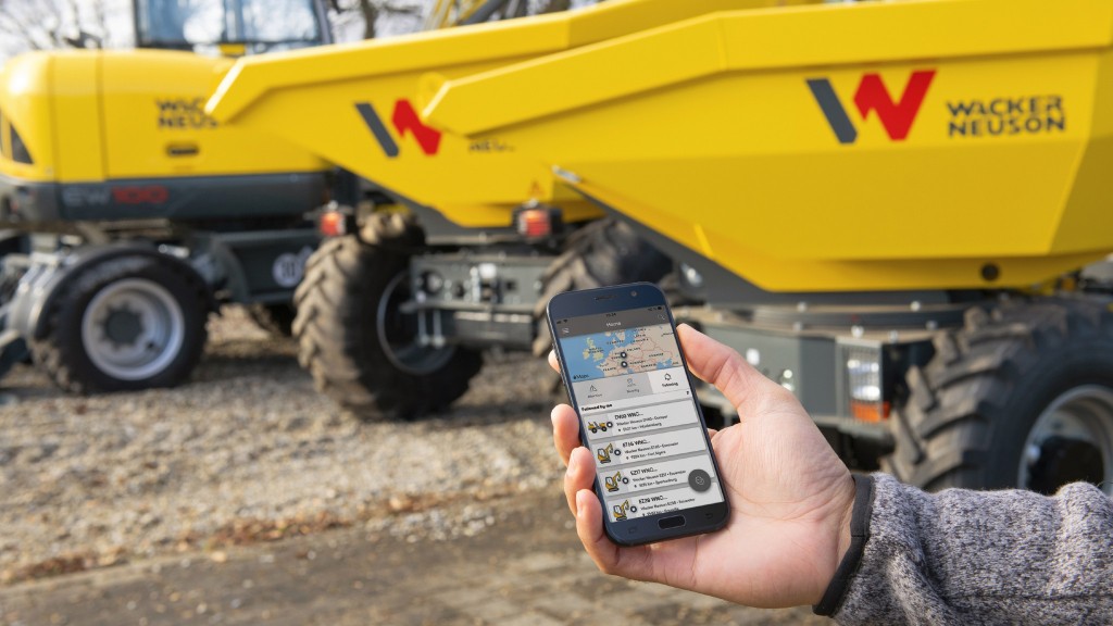 A worker uses a telematics app on a worksite