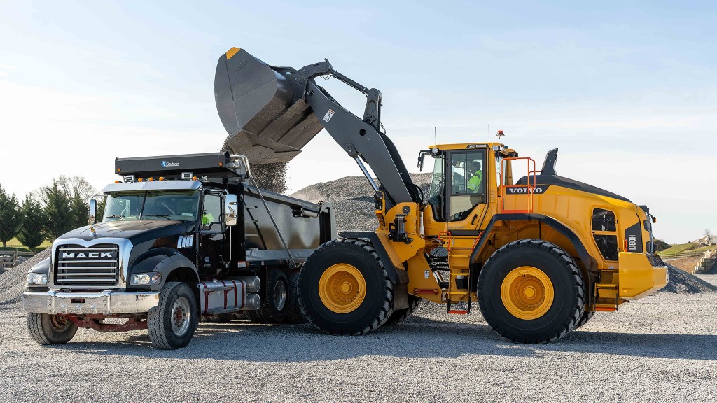 A wheel loader fills a dump truck with aggregate.