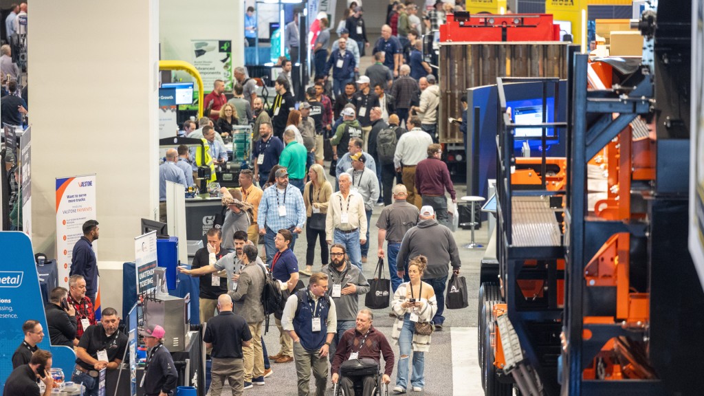 People walk along a pathway at a show floor