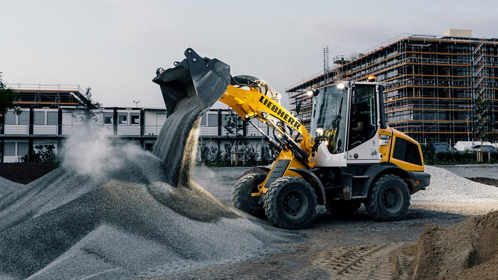 An electric wheel loader moves material on a job site.