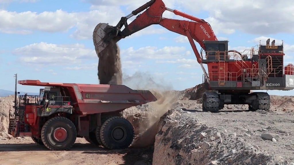 An excavator loads a dump truck