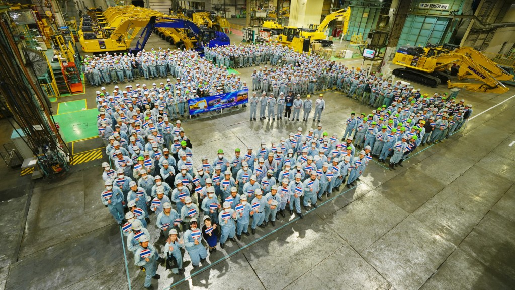 Facility workers line up to form the number 23