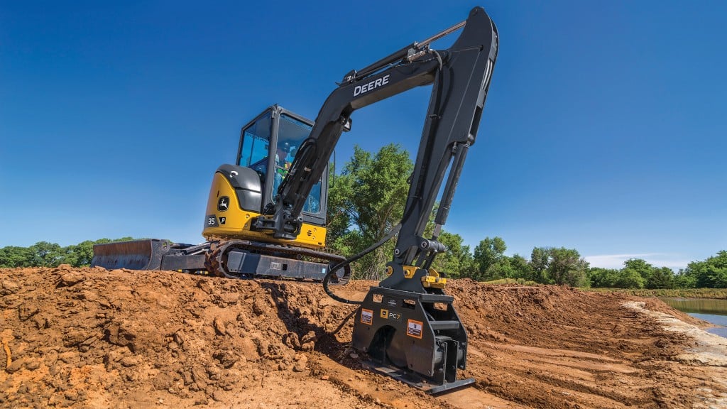A mini excavator uses an attachment to compact dirt on a job site