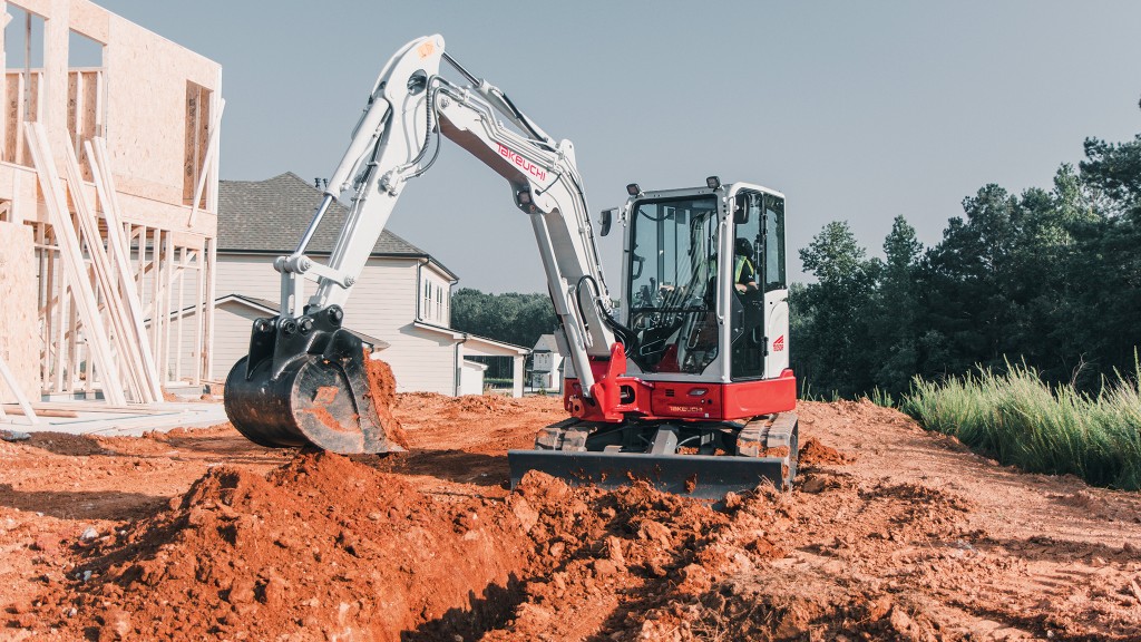 A Takeuchi mini excavator digs a hole at a residential job site