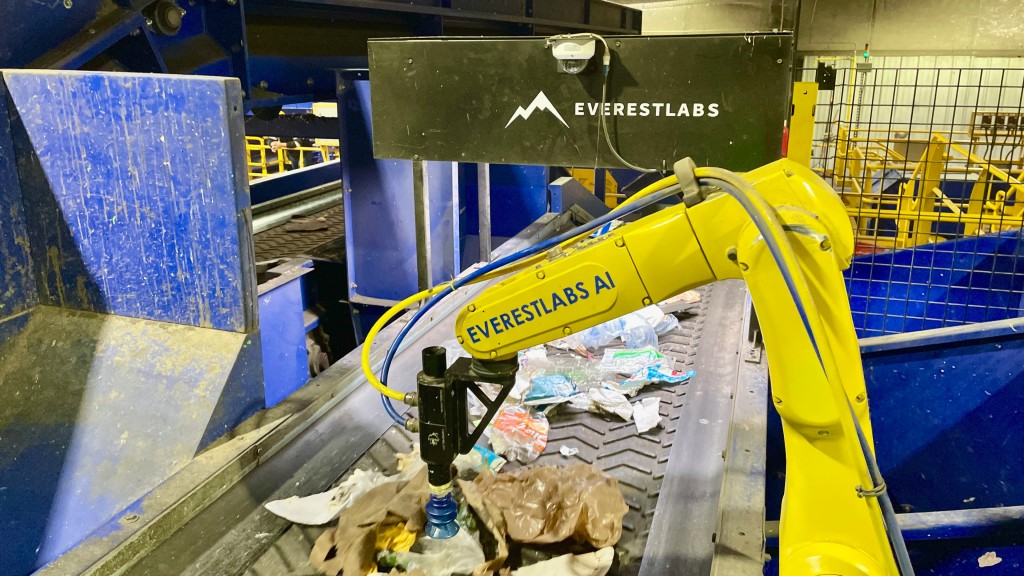 A robot sorts recyclables on a line
