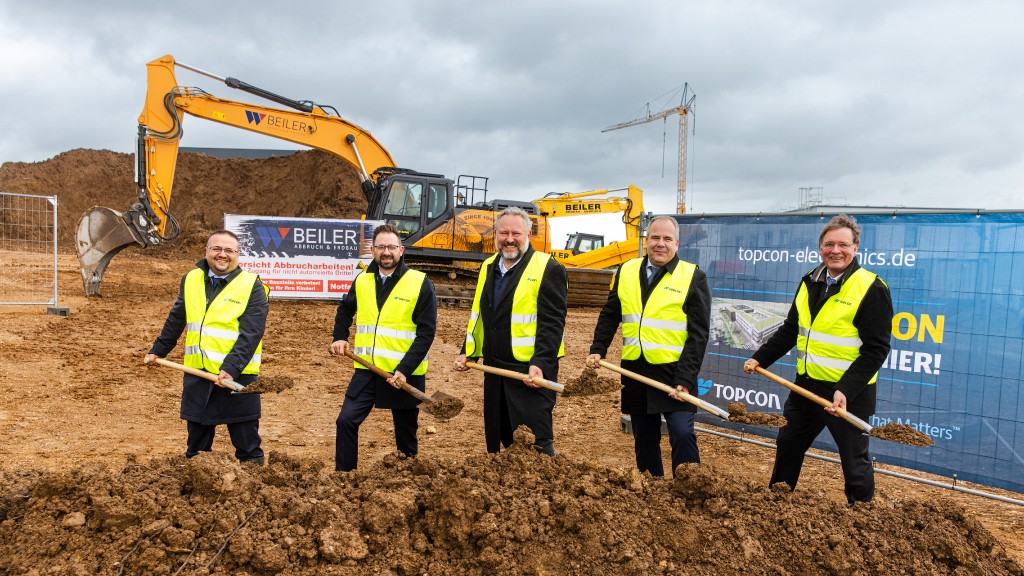 Five people participate in a groundbreaking event