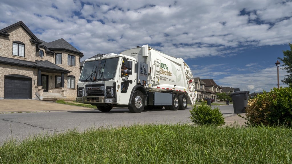 An electric collection vehicle collects waste in a housing subdivision