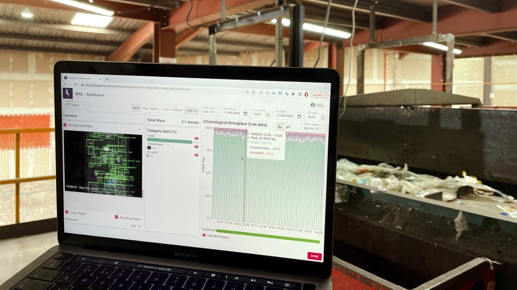 AN AI analyzer analyzes a waste stream, showing the data on a laptop