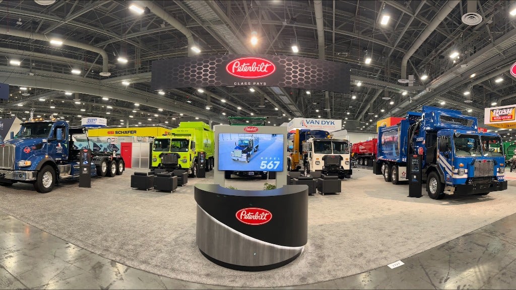 A trade show booth filled with collection trucks