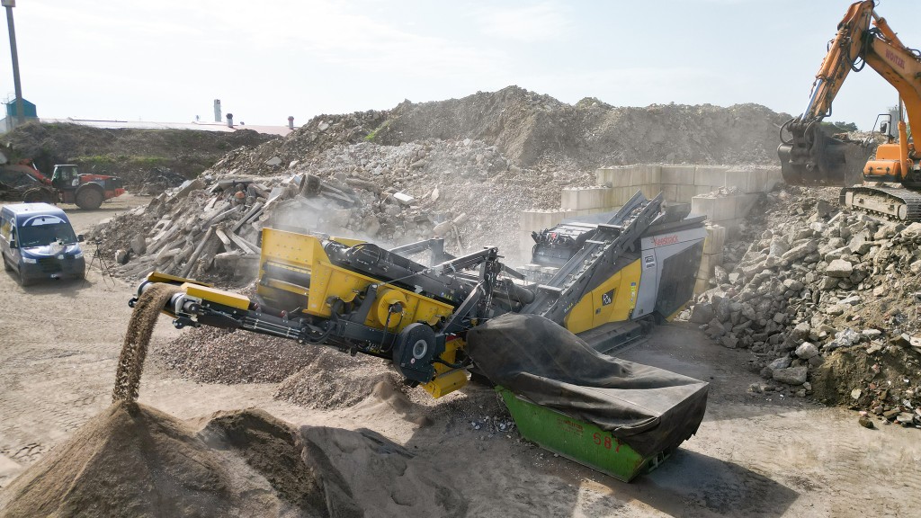 An overhead view of a crusher being loaded in a C&D processing yard.