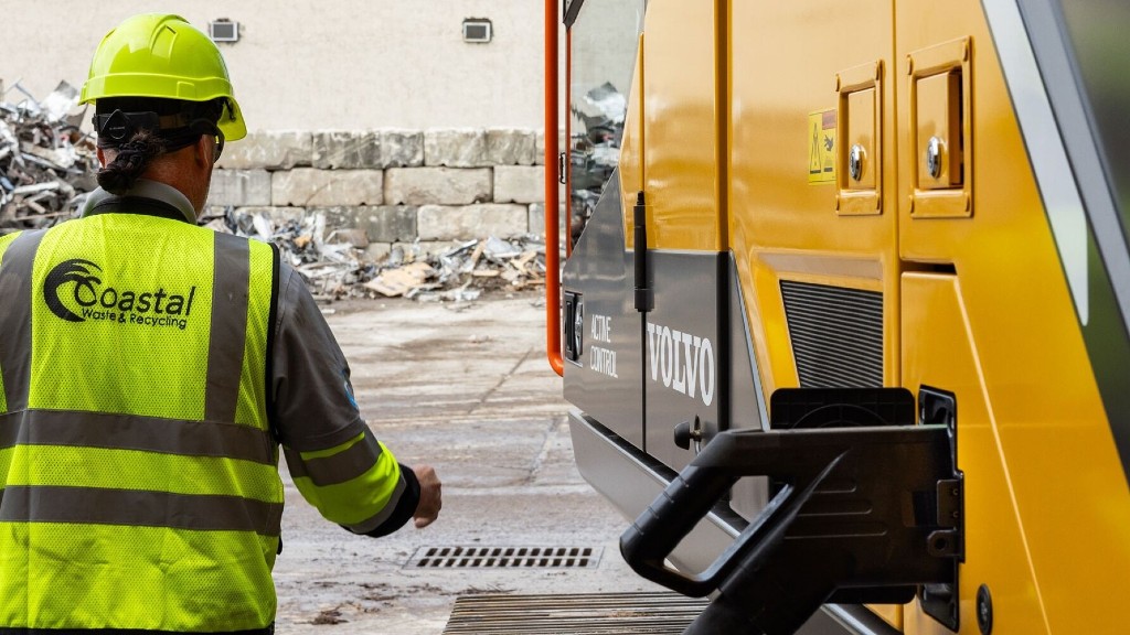 An operator walks to an electric excavator