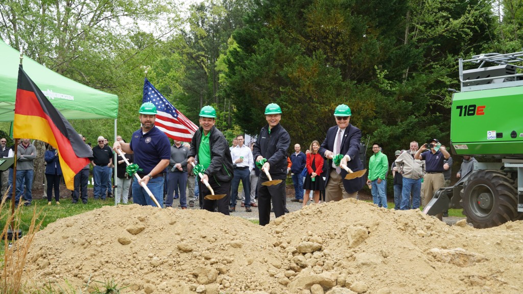 Four people participate in a groundbreaking ceremony