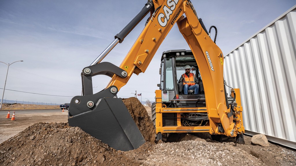 A backhoe loader digs a hole on a job site