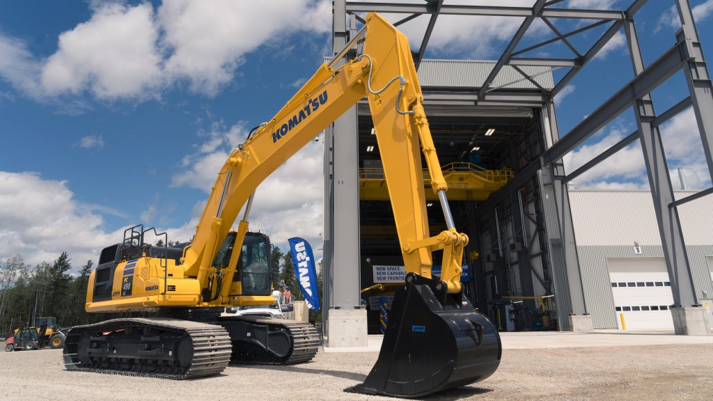 An excavator is parked outside a SMS Equipment facility