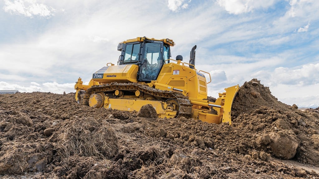 A dozer pushes a large mound of dirt