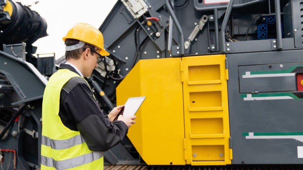 An operator looks at a tablet near a piece of equipment