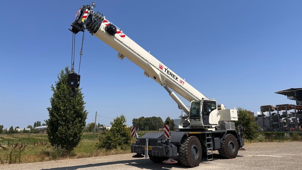 A rough terrain crane is parked in a yard