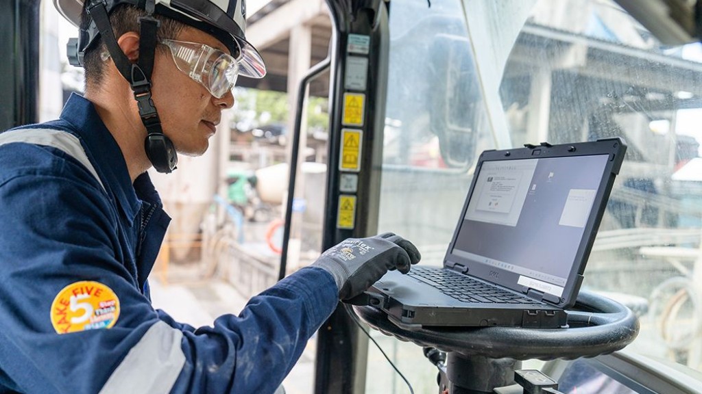 A technician uses a laptop on a job site