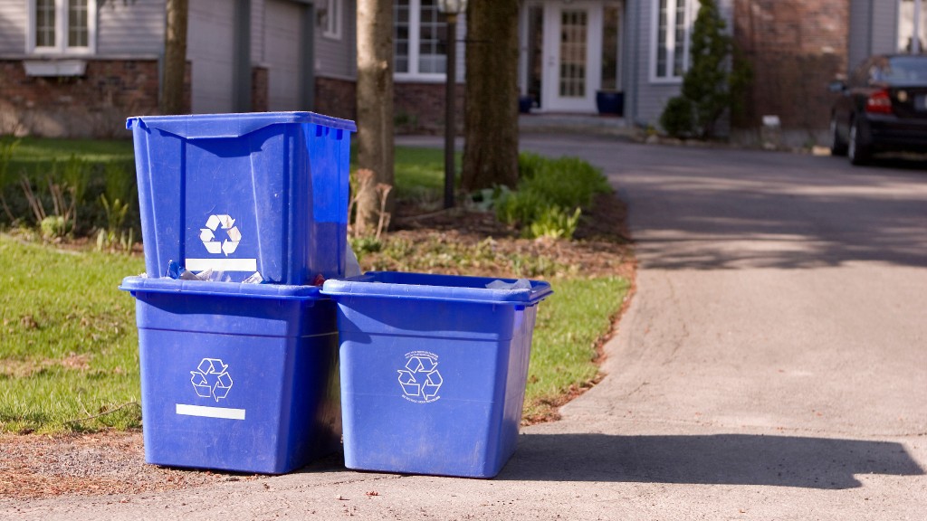 Three blue bins sit at the curb